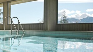 A clear indoor swimming pool with a metal ladder, large windows, and a view of mountains. - Located in Les Collons 1850, only 50 meters from the ski-lifts "La Joc" and "Petit Vallon" (crossbow (Thyon-Les Collons)
