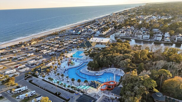 An aerial view of a coastal resort with a large swimming pool, RV parking, and beachfront properties. - Country music festival! Ocean Lake Campground house.  (Myrtle Beach)