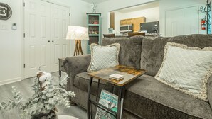 A living room with a grey sofa, a coffee table, a lamp, and a magazine on the table. - ✤VILLA CATALINA✤ Private Studio #103 (Chattanooga)