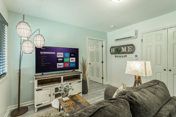 A living room with a flat-screen TV, a wooden coffee table, a gray sofa, and a lamp. - ✤VILLA CATALINA✤ Private Studio #103 (Chattanooga)