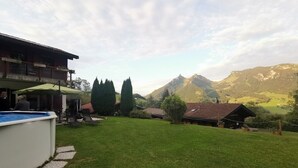 Un jardin avec une piscine, un patio couvert et une vue sur les montagnes.