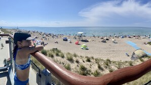 A beach with people, tents, and a lifeguard tower. - The Grey Beach House!! In the heart of Grand Bend (Grand Bend)