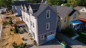 A two-story house with a garage, a covered porch, and a landscaped yard. - The Grey Beach House!! In the heart of Grand Bend (Grand Bend)