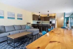 Enjoy meals around the large dining table, surrounded by a comfortable sofa and kitchen area.