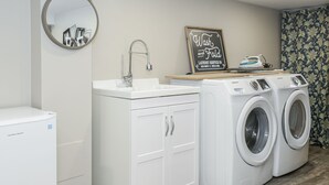 A laundry area with a sink, two washing machines, and a mirror. - Easy Walk to Clifton Hill Falls & Attractions! (Niagara Falls)