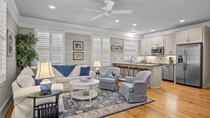 A modern kitchen with a refrigerator, microwave, and island. There is a dining area with a table and chairs. - BB's - Perfect Choice For Your Beaufort Vacation! (Beaufort)