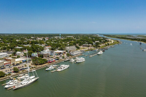 A marina with several yachts docked, surrounded by residential buildings and a clear view of the waterway.