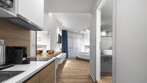 A modern kitchen with a built-in oven, a coffee machine, and a breakfast bar. - Hermes Nilie Hospitality MGMT (Thessaloniki)