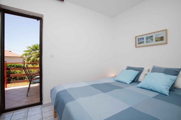 Un dormitorio con cama, almohadas y un cuadro en la pared.
