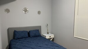 Un dormitorio con cama, mesita de noche y decoración en la pared.