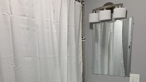 Un baño con lavamanos, espejo y retrete.