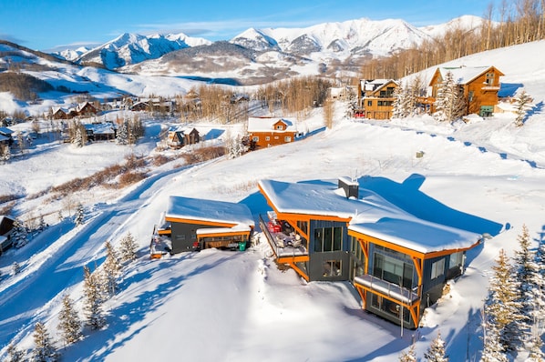 A snow-covered mountain resort with modern buildings and ski slopes.