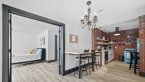 A modern apartment with a kitchen, dining area, and a bedroom with a sliding door.