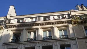 A classical building with multiple balconies and large windows.