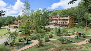 Een resort met meerlaags gebouwen, een golfbaan en een verzorgd landschap.