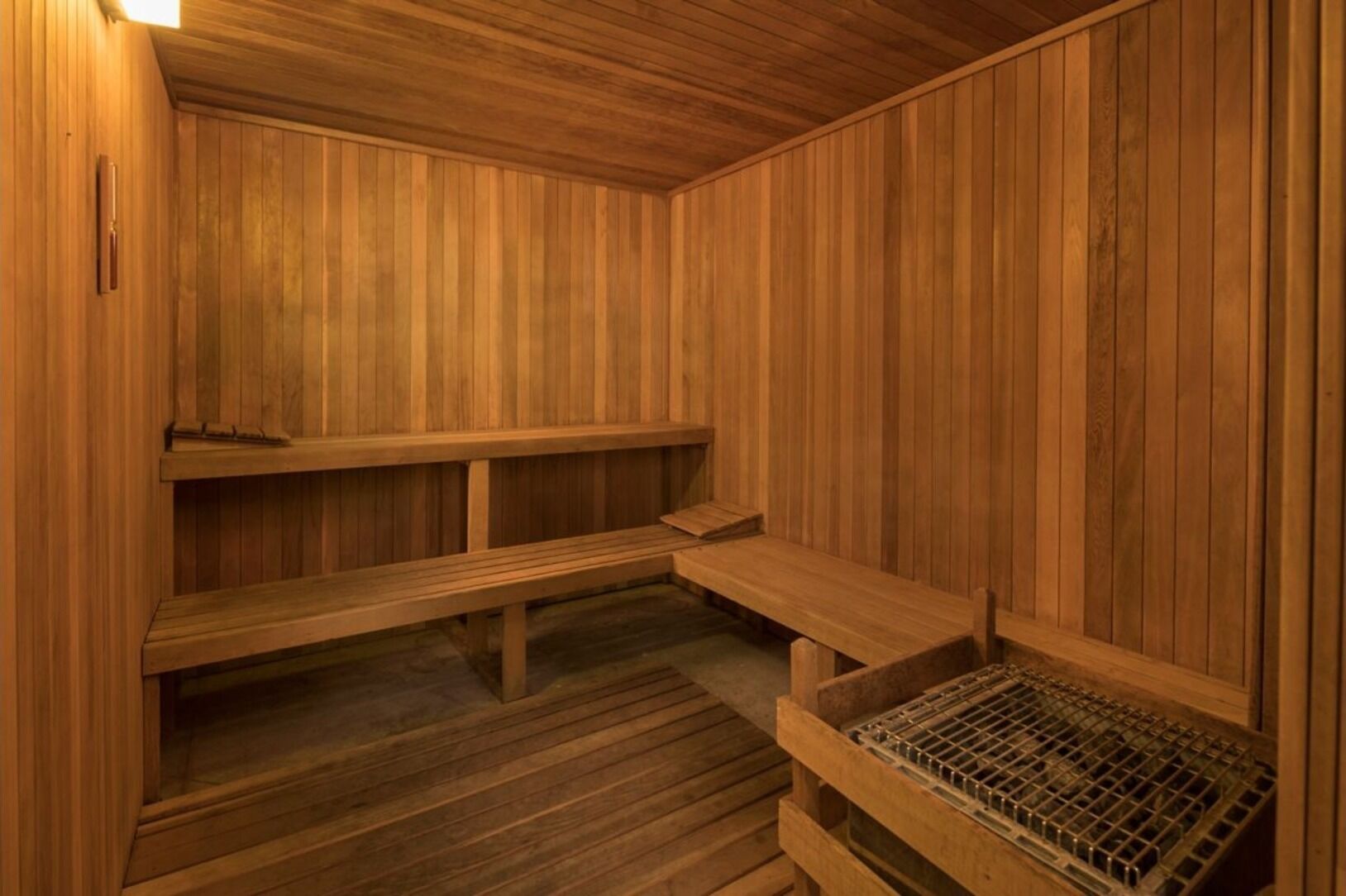 Una sauna de madera con bancos y un asiento.