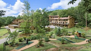 Een resort met meerlaags gebouwen, een golfbaan en een verzorgd landschap.