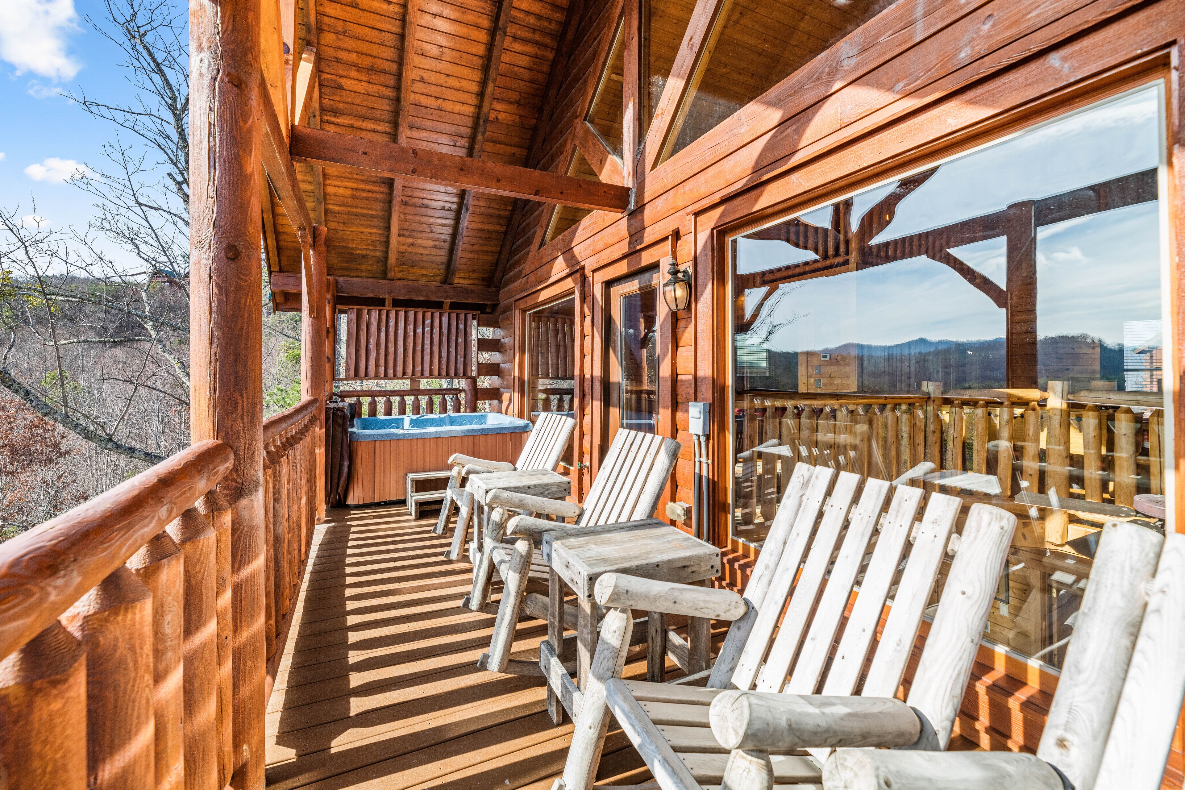 A wooden deck with outdoor seating and a hot tub.
