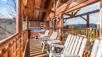 A wooden deck with outdoor seating and a hot tub.