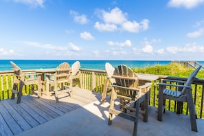 Guests can enjoy ocean views from the elevated deck, surrounded by Adirondack chairs.