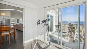 Ein Zimmer mit einem Teleskop auf einem Balkon mit Blick auf den Ozean.