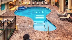 An indoor swimming pool with a curved design, surrounded by lounge chairs and a tiled floor. - Oceanfront Condo/Hawaiian Style. 1Bd, w/AC & Wifi (Kailua-Kona)