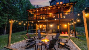 A two-story wooden cabin with a deck, outdoor seating area, and a fire pit. - Private Hiking Trail, Full Game Rm, Great Location (Morganton)