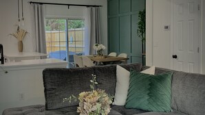 A living room with a gray sofa, a wooden coffee table, and a vase of flowers.