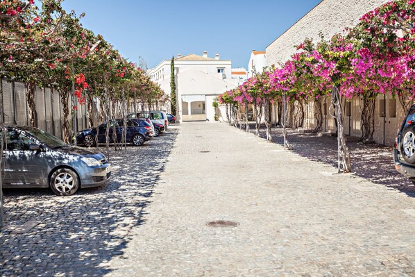 A cobblestone street lined with parked cars and flowering trees. - Historic & Emblematic - Convent of Bernardas (Tavira)