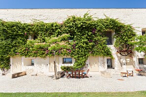 A building with a courtyard, a table with chairs, and a staircase.