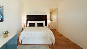 A bedroom with a bed, bedside tables, a nightstand, a rug, and a painting on the wall. - Historic & Emblematic - Convent of Bernardas (Tavira)