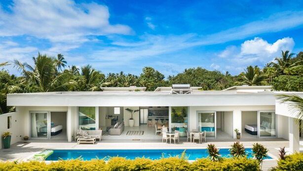A modern house with a pool, large windows, and a garden. - Mama Taras Luxury Villa (Rarotonga)
