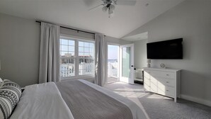 A bedroom with a bed, a dresser, a television, and a balcony with a view of buildings. - ♡ Beautiful Modern & Luxury Beach Home Next to Boardwalk With Bay View (Ocean City)
