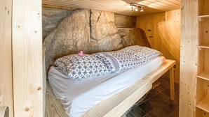 A wooden cabin with a bed, a stone wall, and a tiled floor. - Stunning apartment in Arendal with WiFi (Arendal)