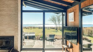 A modern interior with large glass doors leading to an outdoor patio area.