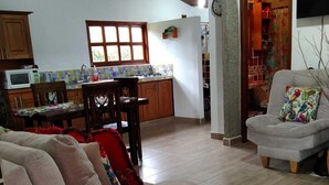 A living room with a sofa, a television, and a kitchen in the background. - Samaria, a place to rest and enjoy in Santa Elena (Santa Elena)