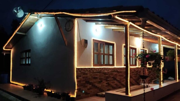 A house with a covered porch, a satellite dish, and a well-lit exterior. - Samaria, a place to rest and enjoy in Santa Elena (Santa Elena)