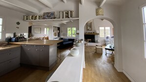 A spacious kitchen with a central island, wooden cabinets, and a dining area with a sofa.