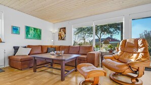 Un salon moderne avec un canapé en cuir marron, une table basse en bois et un fauteuil inclinable en cuir.