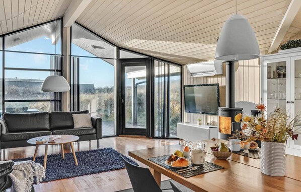 Relax in a spacious living area with expansive views, a comfortable sofa, and a dining table.