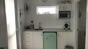 Une cuisine de taille réduite, équipée d’un réfrigérateur, d’un four à micro-ondes et d’une fenêtre.