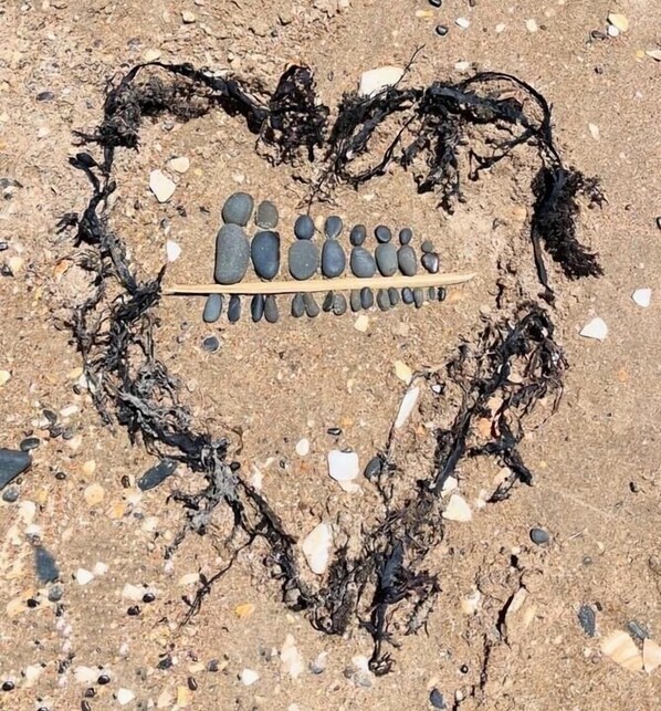 A heart shape made of stones and seaweed on a sandy surface. - Small self contained studio with private deck, 5 mins walk to beach(vaccinated) (Waihi beach)