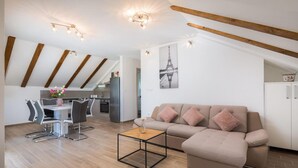 Un appartement moderne comprenant un coin repas, une kitchenette et un salon avec un canapé et une table basse.