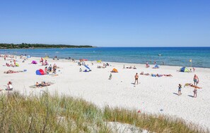 Une plage avec des tentes et des gens qui prennent un bain de soleil.
