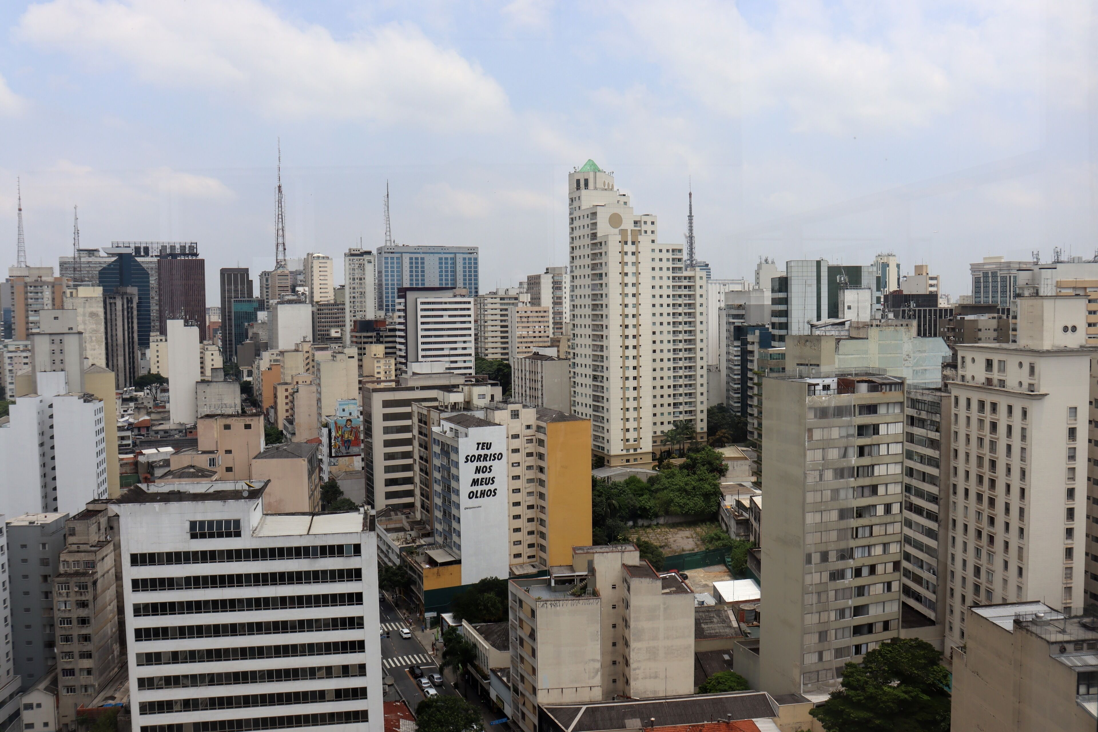 A dense urban skyline with high-rise buildings, some with visible signage and architectural details.