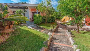 A garden pathway leading to a building with a tiled roof and a door. - 1 bedroom cozy apartment in Palau (Palau)