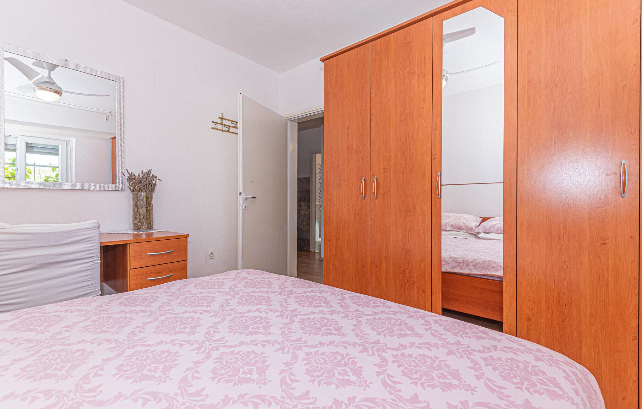 Une chambre à coucher comprenant un lit, une commode, une armoire et un miroir.