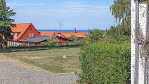 A coastal property with red-roofed buildings, a gravel driveway, and a grassy area.