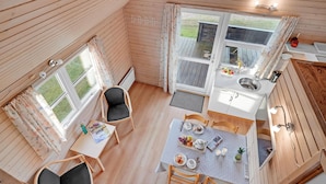 A compact kitchen with a dining area, wooden walls, and large windows. - Amazing home in Struer with kitchen (Struer)