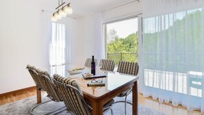 A dining area with a glass table, striped chairs, a bottle of wine, and a bowl of fruit. - Stunning home in Sinj (Sinj)